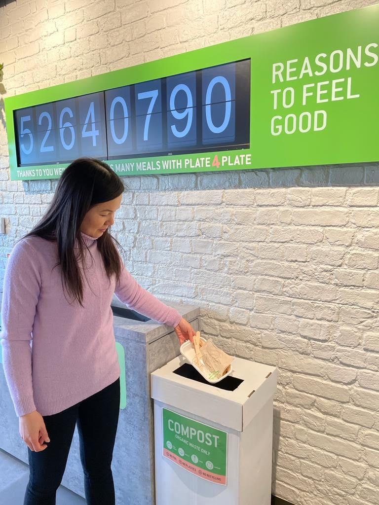 Zambrero UK CEO Emily Teh putting compostable BioPak packaging into the compost bin.