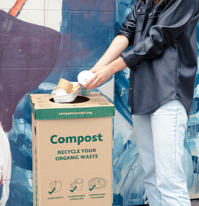 Person putting BioPak compostable packaging into the compost bin